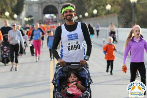 San Diego Thanksgiving 5k runner pushing his child in a stroller