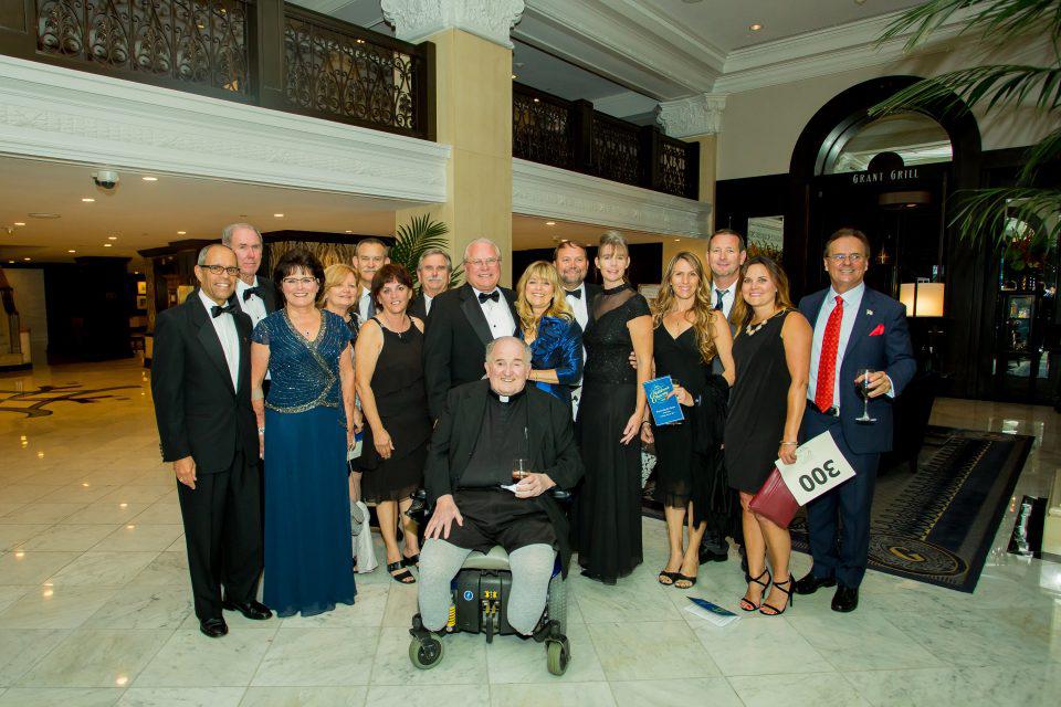 Guests of the Children's Charity Gala gather for a picture in the grand U.S. Grant Hotel.
