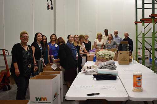 Father Joe and Rotary Club members filling the welcome home kits | San Diego Downtown Breakfast Rotary Club