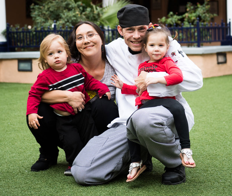 Nina, Stephen and their two kids pose together on the JKC lawn | homeless family help